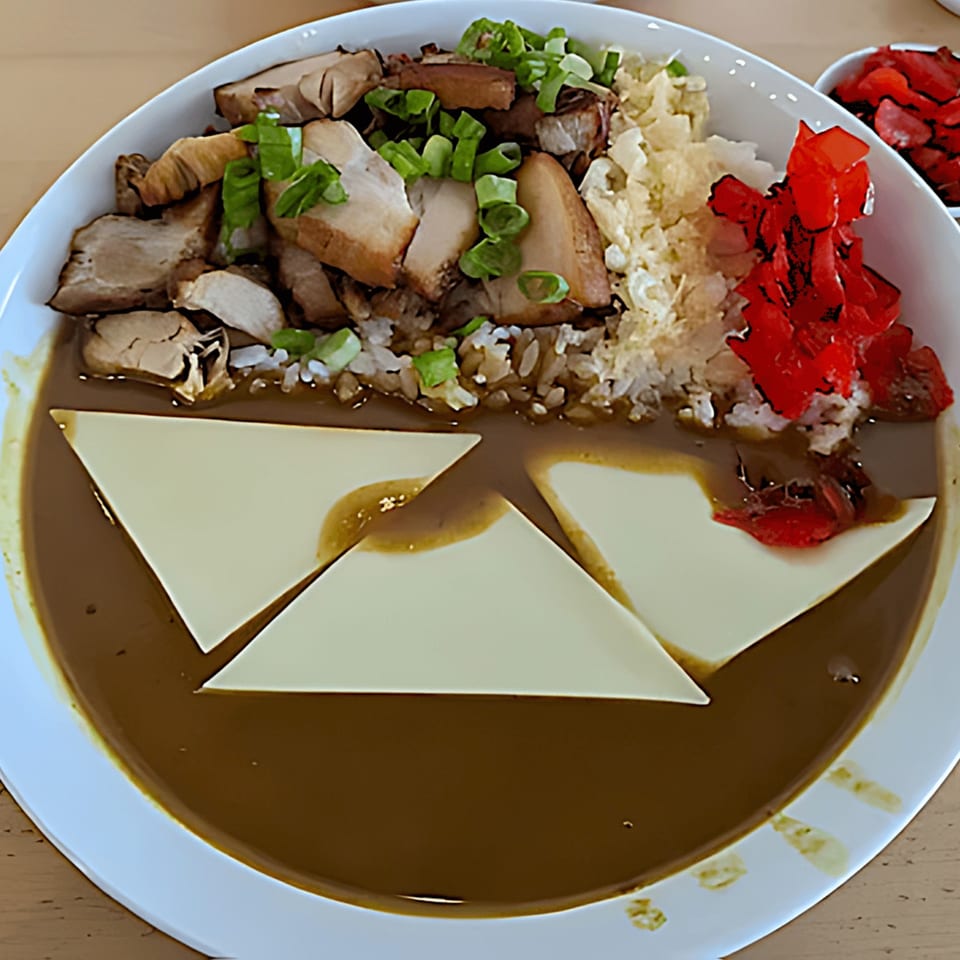 Japanese curry with sliced chicken, rice, pickled ginger, and cheese triangles in a white bowl.