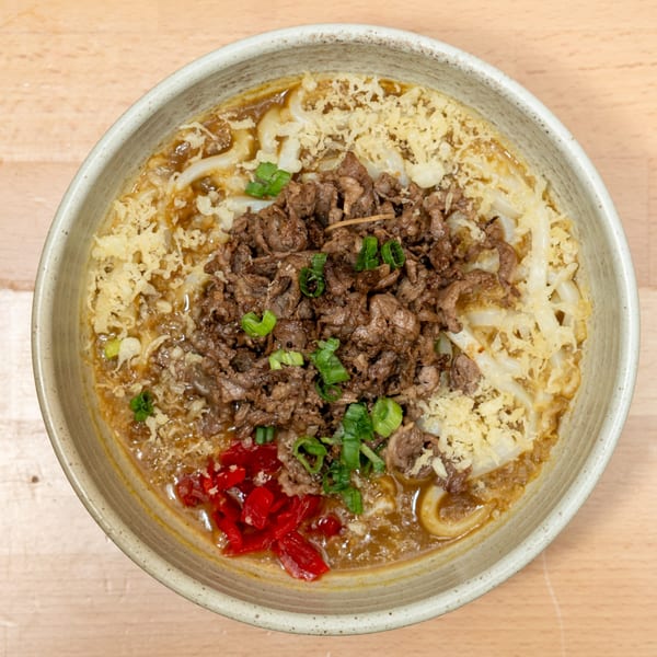 Curry Do's Japanese curry udon with beef, tempura flakes, scallions, and pickled ginger.