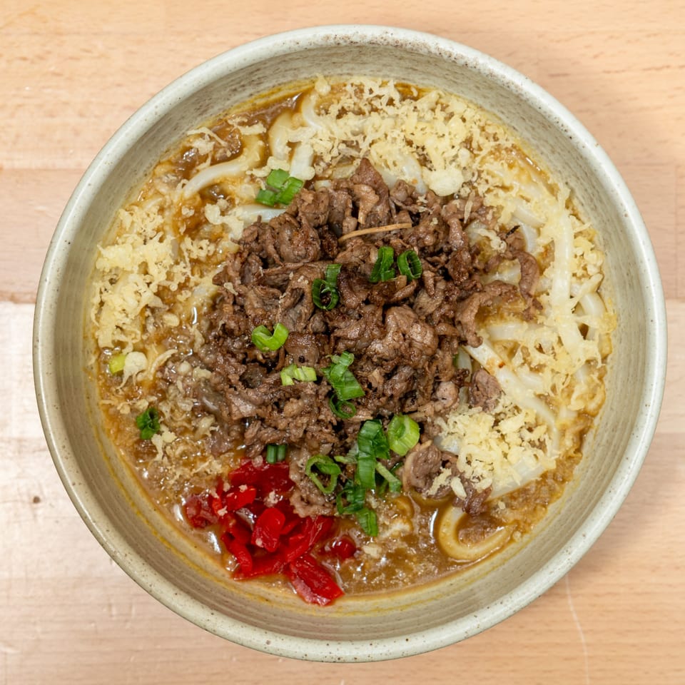 Curry Do's Japanese curry udon with beef, tempura flakes, scallions, and pickled ginger.
