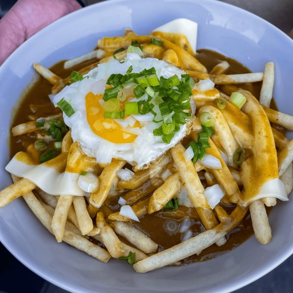 Curry Do's Japanese curry fries topped with a fried egg, cheese, and green onions.
